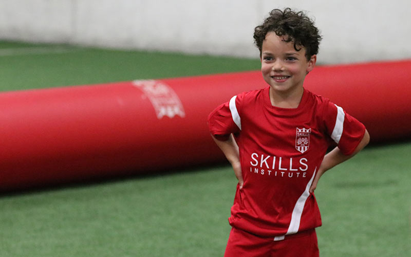 Boy smiles during soccer skills training class at Skills Institute at Arena Sports