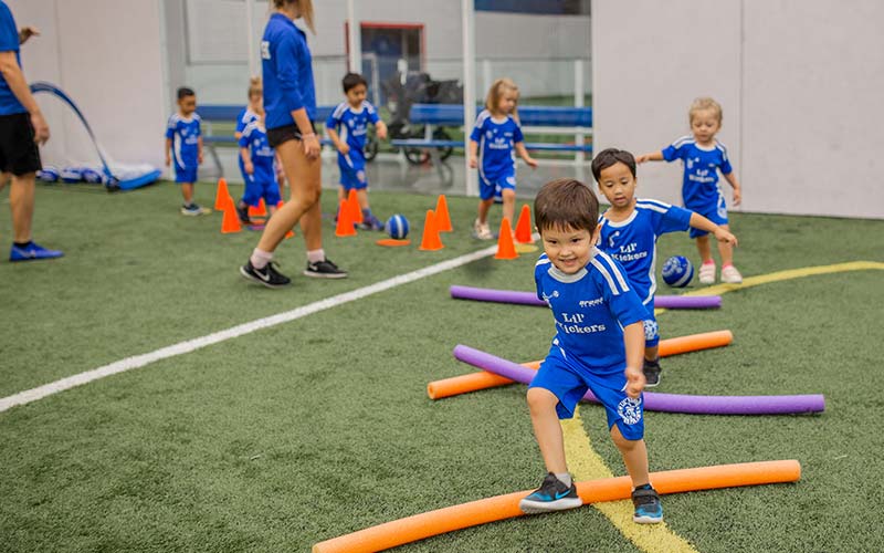 Kids in Lil Kickers uniform practice soccer drill