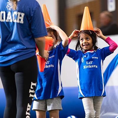 Kids have fun with soccer cones during a Lil' Kickers soccer class at Arena Sports