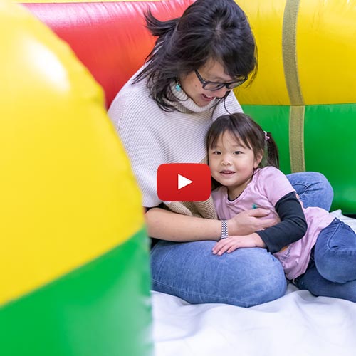 Mom and small child cuddle while in the Inflatable FunZone at Arena Sports SODO