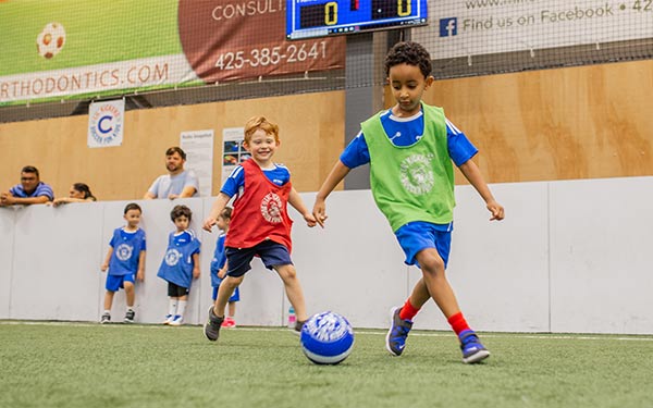 Kids have fun playing soccer in a Lil' Kickers soccer class at Arena Sports